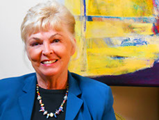 The artist Susan Ray Euler in front of one of her large acrylic paintings.